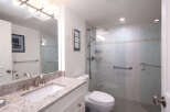 Experience modern comfort in this beautifully appointed bathroom, featuring a spacious walk-in shower with sleek glass doors and convenient grab bars.