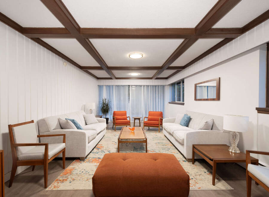 Step into this inviting living room, featuring a stylish coffered ceiling and paneled walls for a touch of classic charm.