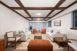 Step into this inviting living room, featuring a stylish coffered ceiling and paneled walls for a touch of classic charm.