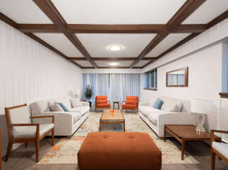 Step into this inviting living room, featuring a stylish coffered ceiling and paneled walls for a touch of classic charm.
