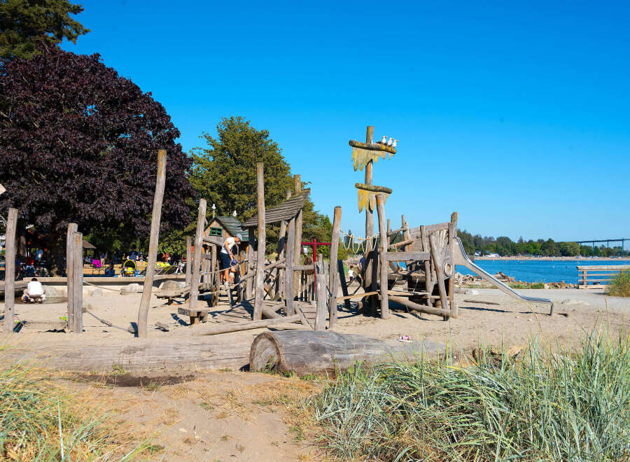 Discover a unique waterfront property featuring a charming, rustic wooden playground perfect for family fun.