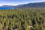Experience the serene beauty of this lakeside property, nestled amidst a dense forest of towering pine trees.
