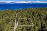 Nestled amidst a dense forest of pine trees, this property offers a serene escape with breathtaking views of a vast, blue lake and distant mountains.