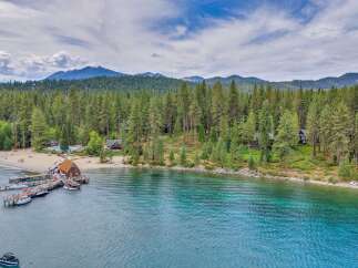 Experience luxury lakeside living with this stunning property featuring a private beach and a picturesque pier with multiple boat slips.