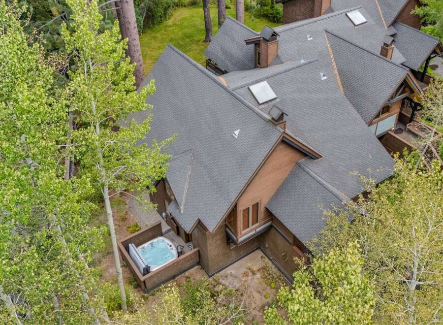 Experience ultimate relaxation in this stunning property featuring a private hot tub, perfect for unwinding amidst lush greenery.