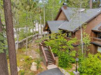Nestled amidst lush greenery and mature trees, this charming home offers a serene mountain retreat.