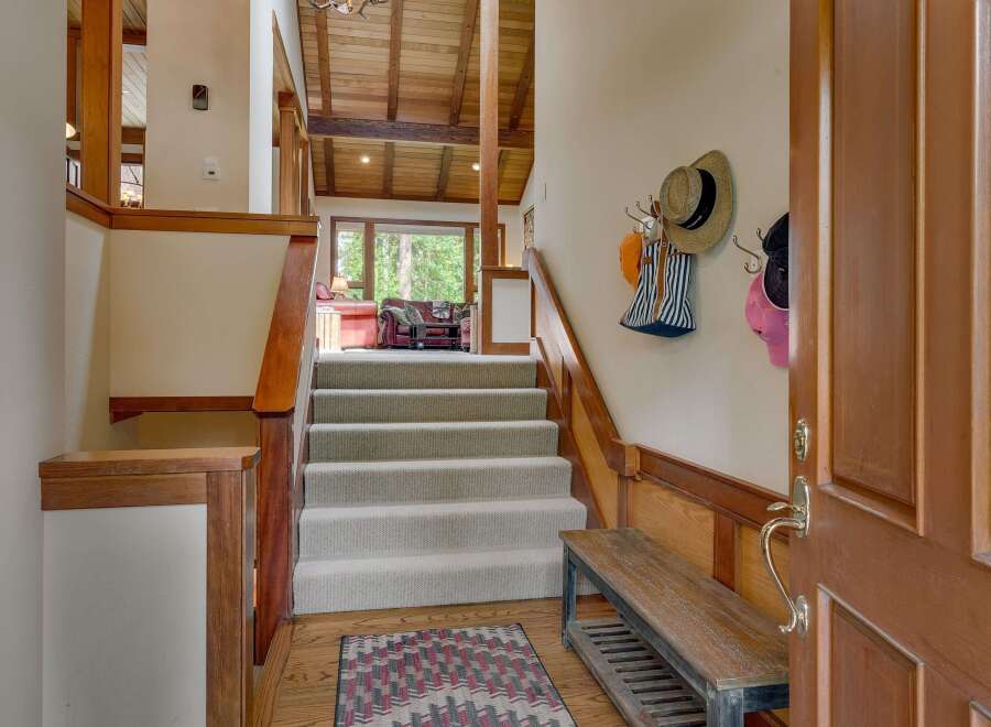 Step into this inviting entryway featuring a grand staircase with plush carpeting, perfect for welcoming guests.