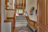 Step into this inviting entryway featuring a grand staircase with plush carpeting, perfect for welcoming guests.