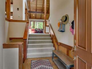 Step into this inviting entryway featuring a grand staircase with plush carpeting, perfect for welcoming guests.
