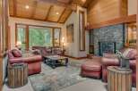 Experience rustic elegance in this stunning living room, featuring a grand stone fireplace and exposed wooden beams that create a warm, inviting atmosphere.