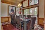 Experience rustic elegance in this inviting dining room, featuring a large wooden table set for a feast and surrounded by comfortable chairs.