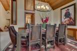 Experience rustic elegance in this spacious dining room, featuring a grand wooden table and chairs perfect for hosting.