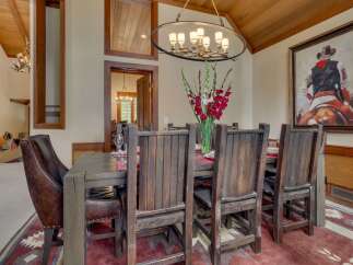 Experience rustic elegance in this spacious dining room, featuring a grand wooden table and chairs perfect for hosting.