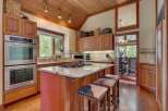 Experience the warmth of this inviting kitchen, featuring rich wood cabinetry and a stunning granite-topped island with bar seating.