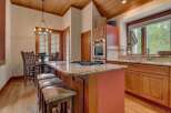 Experience rustic charm in this inviting kitchen, featuring a spacious granite-topped island with a gas range and comfortable seating.