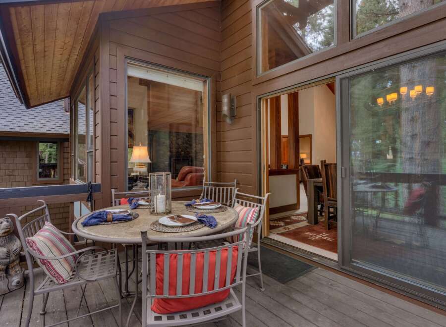 Enjoy outdoor dining on this charming deck, complete with a round table set for four and comfortable seating.