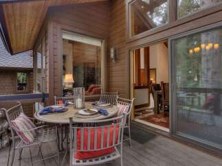 Enjoy outdoor dining on this charming deck, complete with a round table set for four and comfortable seating.
