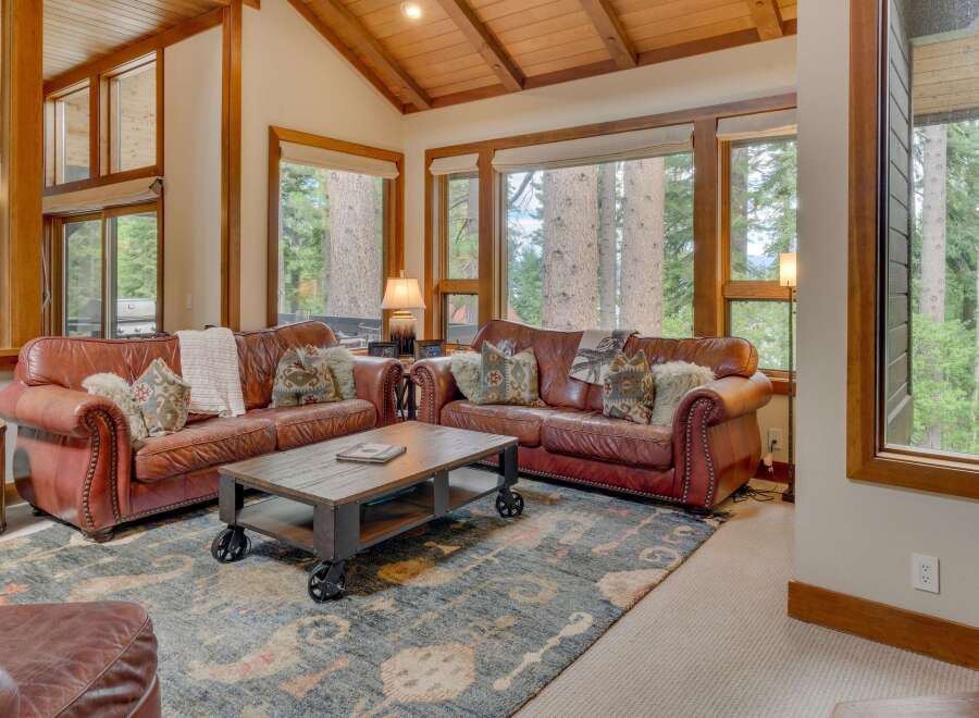 Experience rustic charm in this inviting living room, featuring plush leather sofas and a striking wooden coffee table.