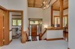 Step into this stunning entryway featuring a grand wooden staircase and a unique antler chandelier that adds a rustic charm.