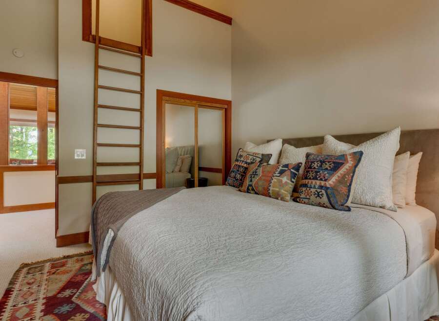 Experience rustic charm in this inviting bedroom, featuring a cozy queen-size bed adorned with decorative pillows and a plush throw.