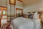 Experience rustic charm in this inviting bedroom, featuring a cozy queen-size bed adorned with decorative pillows and a plush throw.