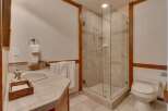 This bathroom features a spacious glass-enclosed shower with tiled walls and a built-in soap dish.