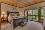 Experience rustic charm in this master bedroom, featuring a grand dark wood bed adorned with Native American-inspired pillows and a cozy throw.