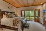 Experience rustic charm in this master bedroom, featuring a grand wooden bed adorned with patterned pillows and a cozy blanket.