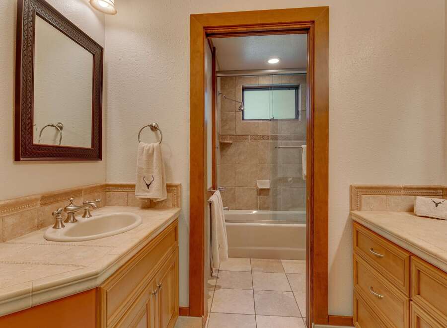 This bathroom features a spacious vanity with a double sink and ample counter space, perfect for busy mornings.