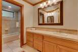 This bathroom features a spacious vanity with ample storage and a large mirror, perfect for your morning routine.
