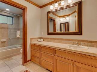 This bathroom features a spacious vanity with ample storage and a large mirror, perfect for your morning routine.