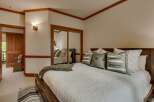 Experience ultimate comfort in this beautifully appointed bedroom, featuring a plush king-sized bed adorned with decorative pillows and a cozy throw.