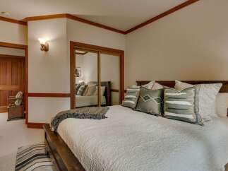 Experience ultimate comfort in this beautifully appointed bedroom, featuring a plush king-sized bed adorned with decorative pillows and a cozy throw.