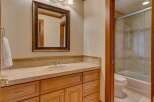 This bathroom features a spacious vanity with a tiled countertop and ample storage, complemented by a large, ornate mirror.