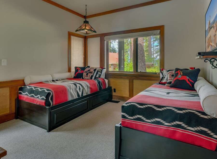 This charming bedroom features two twin beds adorned with cozy, southwestern-inspired blankets and decorative pillows.