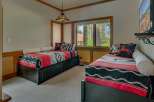 This charming bedroom features two twin beds adorned with cozy, southwestern-inspired blankets and decorative pillows.