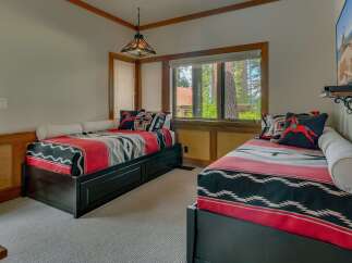 This charming bedroom features two twin beds adorned with cozy, southwestern-inspired blankets and decorative pillows.