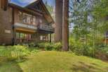 Nestled amidst towering trees, this stunning multi-level home offers a serene retreat with its natural wood siding and expansive windows.