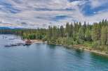 Experience lakeside luxury with this stunning aerial view of a property featuring a private dock with multiple boats and a charming boathouse.