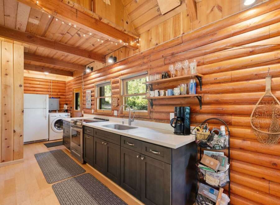Experience rustic charm in this cozy log cabin kitchen, featuring warm wood interiors and a functional layout.