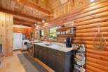 Experience rustic charm in this cozy log cabin kitchen, featuring warm wood interiors and a functional layout.