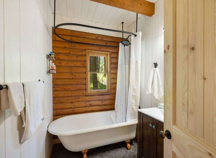 Experience rustic charm in this bathroom featuring a clawfoot tub with ornate legs, perfect for a relaxing soak.