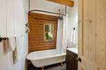 Experience rustic charm in this bathroom featuring a clawfoot tub with ornate legs, perfect for a relaxing soak.