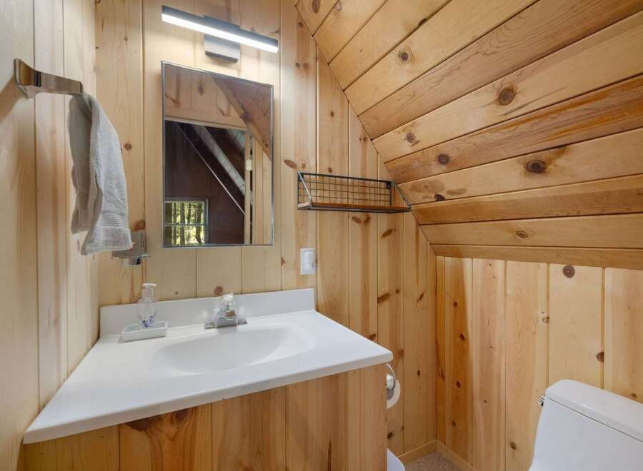 This charming bathroom features a rustic wood-paneled design, creating a warm and inviting atmosphere.