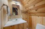 This charming bathroom features a rustic wood-paneled design, creating a warm and inviting atmosphere.