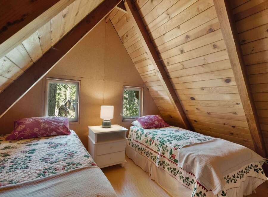 Discover this charming attic bedroom featuring two cozy twin beds, perfect for guests or family.