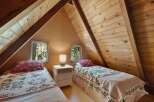 Discover this charming attic bedroom featuring two cozy twin beds, perfect for guests or family.