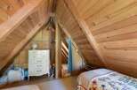 Discover unique living spaces with this charming attic bedroom, featuring exposed wooden beams and a cozy, rustic ambiance.