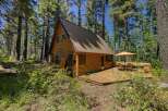 Escape to this charming A-frame cabin nestled amongst tall pine trees, offering a serene forest retreat.