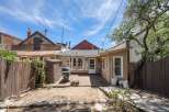 Enjoy outdoor living in this charming backyard featuring a spacious deck perfect for entertaining, complete with a grill and a convenient storage shed.